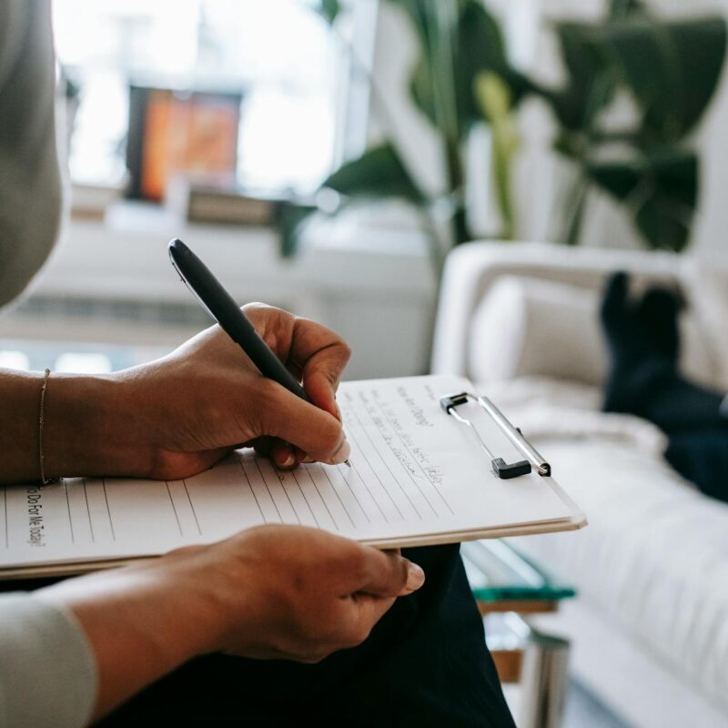A person fills out a form on a clipboard.